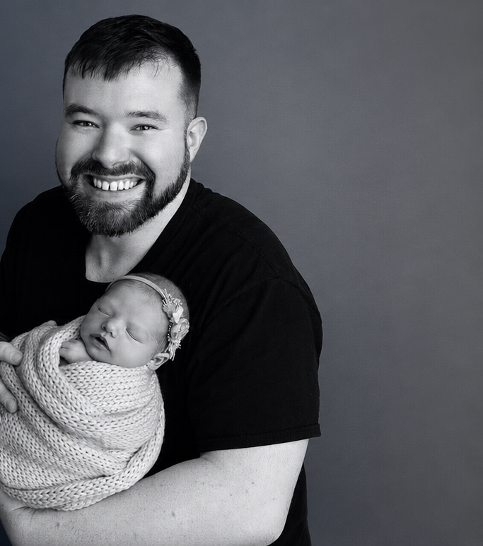 Timothy Thompson holding a newborn
